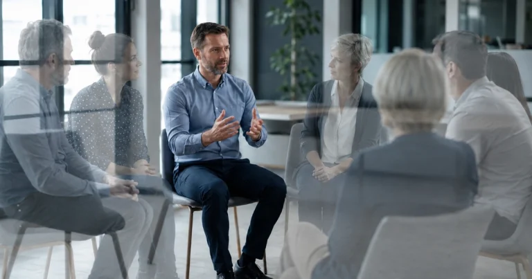 Groupe de managers en cercle échangeant lors d'une séance de communauté de pairs