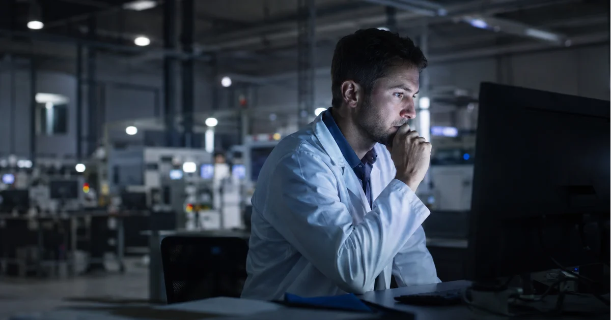 Un expert promu manager travaille seul tard le soir, illustrant le piège du manager expert.